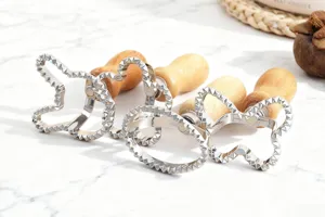 Set di stampini per biscotti in acciaio inox con manici in legno per forme festive.