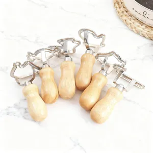 Set di 6 tagliabiscotti in acciaio inox con manici in legno ergonomici su marmo