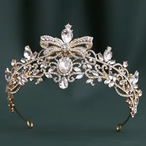 Close-up of golden baroque rhinestone bridal tiara with elegant bow and sparkling crystals.
