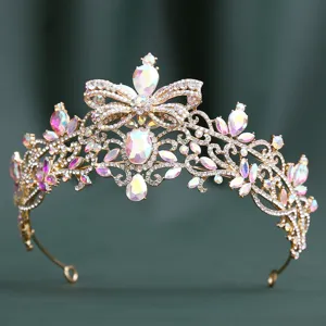 Close-up detail of luxury gold rhinestone tiara with butterfly motif and crystal sparkle.