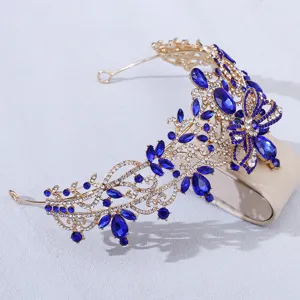 Close-up view of a gorgeous gold baroque tiara with blue and clear rhinestones.