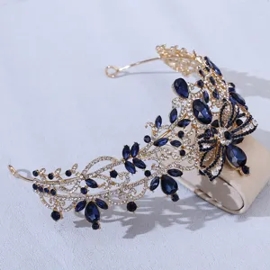 Close-up of the elegant gold baroque crown adorned with sparkling blue crystals and rhinestones.