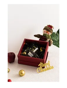 Caja de regalo de Navidad roja y elegante con relleno negro y luces decorativas.