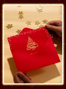 Vista detallada de una tarjeta de felicitación navideña roja con relieve dorado y estrellas.