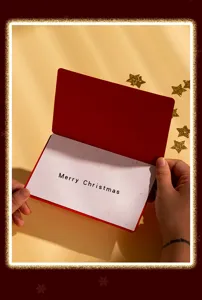 Vista detallada de tarjeta de felicitacion navideña con cubierta roja y gran mensaje.