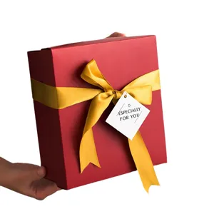 Caja de regalo navideña roja con cinta dorada, elegante empaque festivo para presentes.