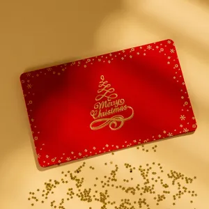 Tarjeta de felicitación navideña roja con estampado en oro de árbol y texto festivo.