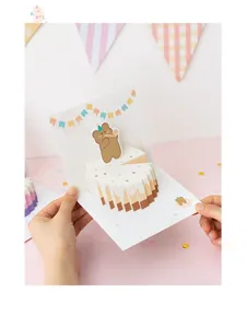Vista detallada de tarjeta de felicitación pop-up 3D con oso y pastel para regalos lindos.