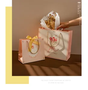 Bolsas de regalo de papel rosa tulipán con cintas y asas para fiestas y embalajes de regalos.