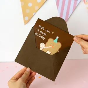 Tarjeta de felicitación de cumpleaños 3D creativa con tierno diseño de oso y sobre marrón.