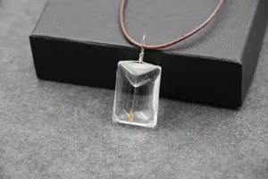 Handgemaakte transparante hars rechthoekige paardebloem zaad hanger ketting in detail.
