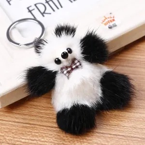 Vista detallada de un bonito colgante de bolso panda de pelo de visón negro y blanco.