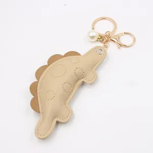 Detailed view of the cute dinosaur keychain pendant featuring soft leather and pearls.