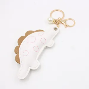 Cute dinosaur keychain bag charm with pearl and metal hardware for backpack decoration.