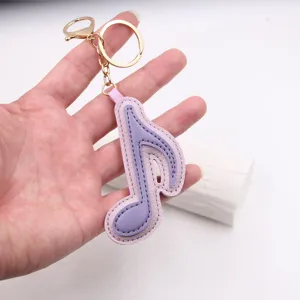 Portachiavi con nota musicale in pelle viola, dettagli in metallo dorato raffinati.