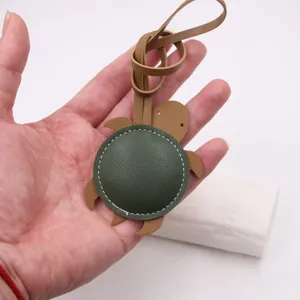 Detailed shot of a cute green leather sea turtle bag charm with a long strap accessory.