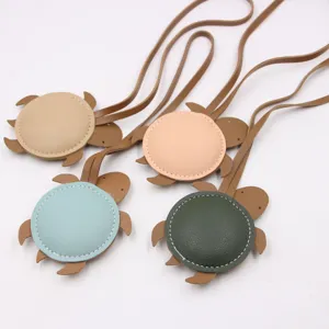 Detail view of cute stuffed leather sea turtle bag charms with long straps, multi-color.