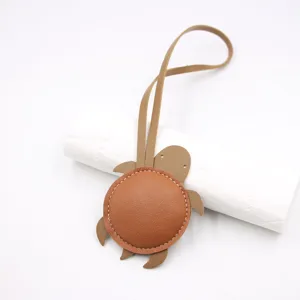 Detailed view of cute leather turtle bag charm with contrast stitching and convenient lanyard strap.