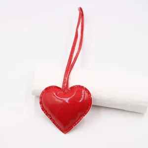 Red glossy heart leather bag strap pendant, fashion clothing accessory charm for jeans and bags.