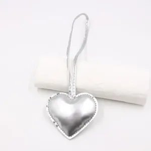 Detail shot of the glossy silver leather heart pendant charm with hanging strap for bags.