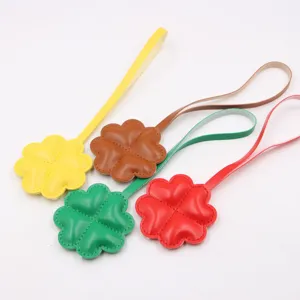 Vue détaillée de charms trèfle en cuir coloré, fabrication de qualité et finitions.