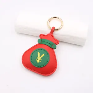 Dettaglio in primo piano di un portachiavi a borsa in pelle rosso e verde con simbolo yen.