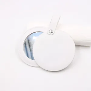 Portable round pocket mirror with white leather case and metal snap strap for makeup.