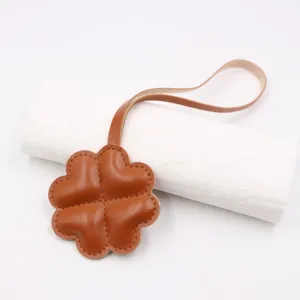 Pendentif de sac trèfle à quatre feuilles en cuir marron accessoire de mode élégant.