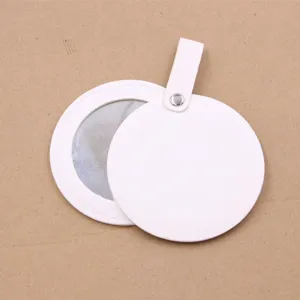 Close-up of portable white leather round makeup mirror detail with hanging strap and snap button.