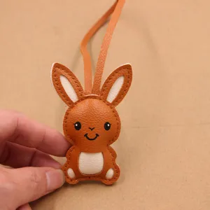 Vue détaillée du charm de sac mignon en cuir PU orange avec des coutures fines et soignées.