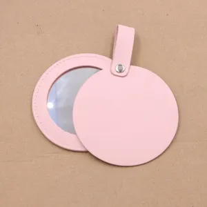 Pink leather round portable pocket makeup mirror detail, compact hanging accessory design.