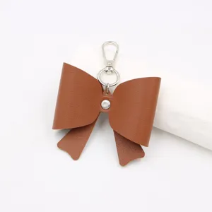 Close-up van bruine lederen strik sleutelhanger hanger, perfect stijlvol tas accessoire detail.