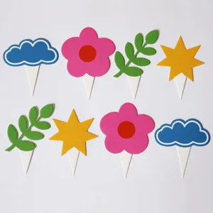 Close-up detail of colorful dopamine style cake toppers including cute clouds, flowers and stars.