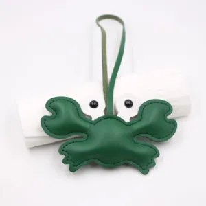 Detailed view of the green leather crab bag charm, featuring fine stitching and loop strap.