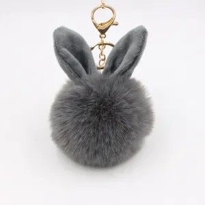 Fluffy grey rabbit ear plush pom pom keychain bag charm with shiny gold metal clasp.