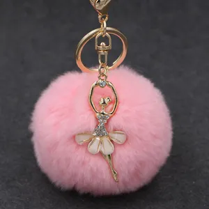 Primer plano detallado del pompon de pelo sintetico rosa esponjoso con colgante de bailarina con estrás.