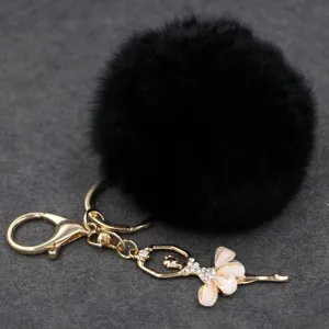 Detalle de primer plano del llavero pompón de felpa negra con colgante de bailarina con estrás.