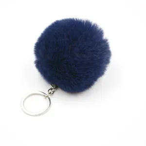 Dark blue fluffy faux rabbit fur ball keychain pendant detail closeup display shot.