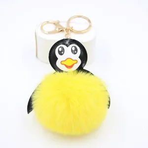 Primo piano dettagliato di un simpatico portachiavi a pinguino soffice giallo con anello.