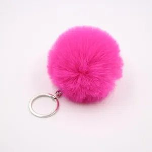 Close-up of hot pink fluffy pom pom keychain with silver metal ring, plush bag charm detail