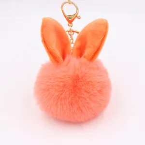 Cute plush rabbit ear pom pom keychain for bags, soft faux fur charm with gold metal clasp.