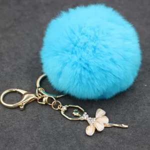 Llavero de pompón azul esponjoso con colgante de bailarina de diamantes y cierre dorado.