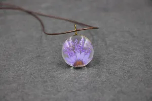 Detailed close-up view of the handmade purple dried flower glass resin pendant necklace.
