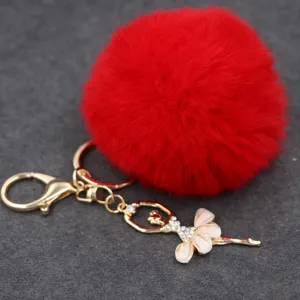 Llavero de pompón esponjoso rojo con detalle de colgante de bailarina de diamantes de imitación.