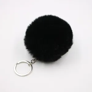 Black faux fur pom pom keychain detail showing soft fluffy texture and silver metal ring.