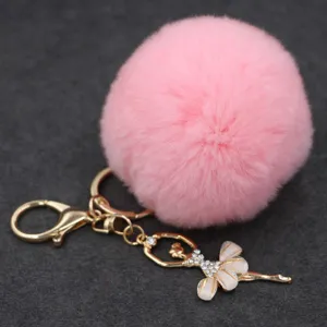 Llavero de pompón rosa esponjoso con dijes de bailarina de ballet con diamantes de imitación.