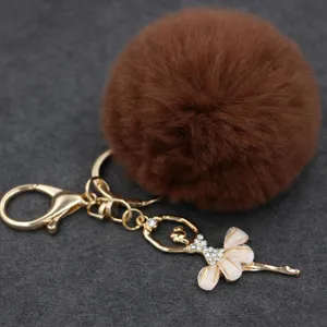 Vista detallada del bonito llavero de bailarina con pedrería y pompón de peluche marrón.