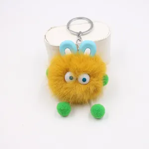 Fluffy yellow plush monster keychain with big eyes and blue ears, cute bag pendant charm.