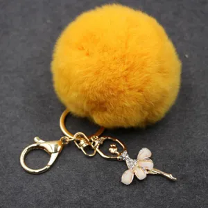 Llavero de pompón de felpa esponjosa amarilla con colgante de bailarina de diamantes.