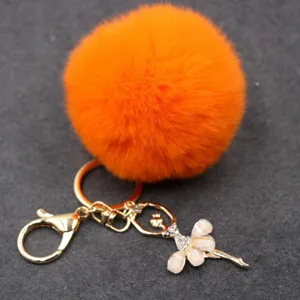 Lindo llavero de pompón naranja esponjoso con colgante de bailarina de pedrería